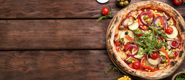 Top view of hot delicious pizza on wooden table, space for text. Banner design 