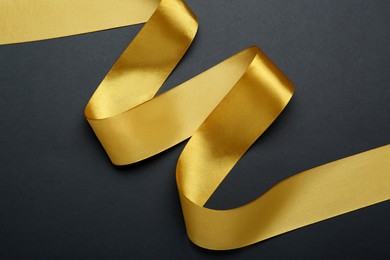 Beautiful golden ribbon on black background, top view