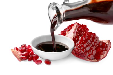 Photo of Pouring pomegranate sauce into bowl and fresh ripe fruit on white background