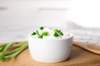 Fresh sour cream with onion on wooden board, closeup