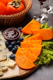 Photo of Delicious persimmon, blue cheese, blueberries and jam served on light grey table