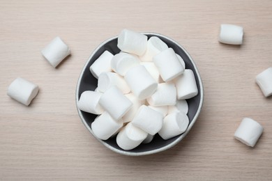 Delicious puffy marshmallows on wooden table, flat lay