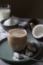 Photo of Glass of coffee with coconut milk, pieces and flakes on light table, space for text