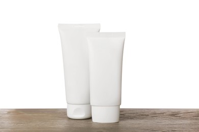 Tubes of hand cream on wooden table against white background