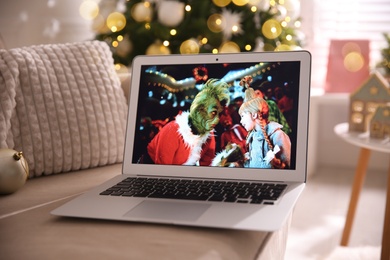 MYKOLAIV, UKRAINE - DECEMBER 25, 2020: Modern laptop displaying The Grinch movie indoors. Cozy winter holidays atmosphere