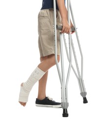 Boy with injured leg using crutches on white background, closeup