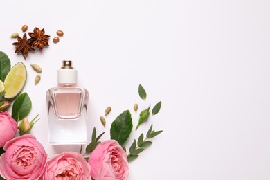 Photo of Flat lay composition with bottle of perfume, lime and beautiful flowers on white background. Space for text