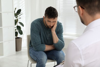 Psychotherapist working with drug addicted man indoors