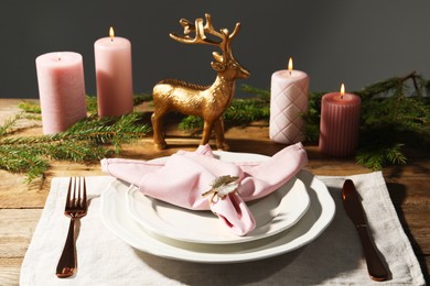 Stylish table setting with pink fabric napkin, beautiful decorative ring and festive decor on wooden background