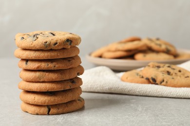 Photo of Stack of tasty chocolate chip cookies on grey table. Space for text