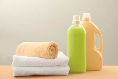 Different bottles with detergents and towels on table