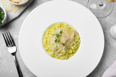 Delicious risotto with cheese on grey marble table, flat lay