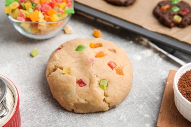 Unbaked cookie with candied fruits on grey table, closeup