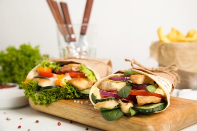 Photo of Delicious shawarmas with chicken and fresh vegetables on white table