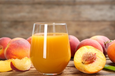 Natural peach juice and fresh fruits on wooden table, closeup