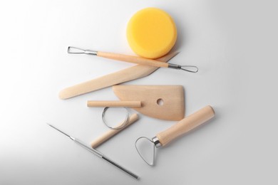 Set of clay modeling tools on white background, flat lay