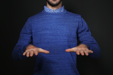 Photo of Man showing BLESS gesture in sign language on black background, closeup