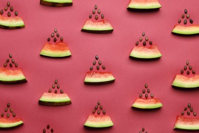 Photo of Flat lay composition with slices of watermelon and seeds on crimson background