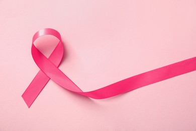 Photo of Pink ribbon on color background, top view. Breast cancer awareness concept