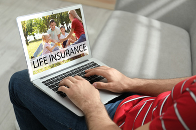 Image of Man with modern laptop indoors, closeup. Life insurance