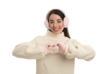 Beautiful young woman wearing earmuffs on white background