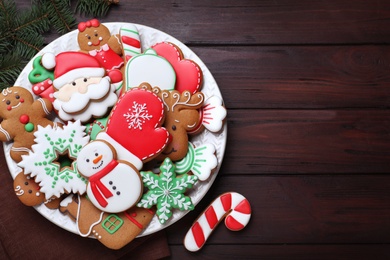 Delicious gingerbread Christmas cookies on wooden table, flat lay. Space for text