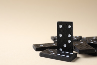 Black domino tiles on beige background. Space for text