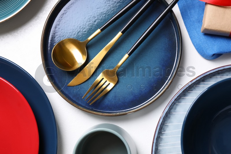 Set of dishware and cutlery on white background, flat lay