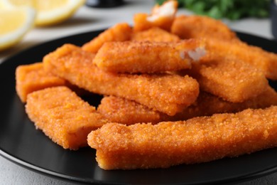Fresh breaded fish fingers on plate, closeup