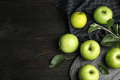 Flat lay composition of fresh ripe green apples on black wooden table, space for text