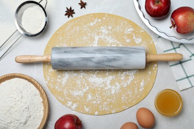 Flat lay composition with raw dough and ingredients on light grey table. Baking apple pie