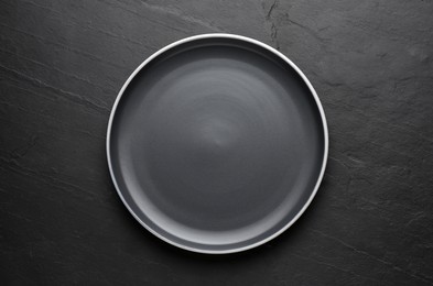 New dark plate on black table, top view