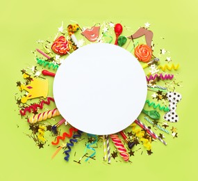 Photo of Frame of festive items on light green background, flat lay with space for text. Surprise party concept