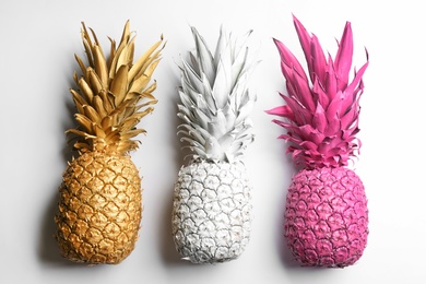 Painted pineapples on white background, top view. Creative concept