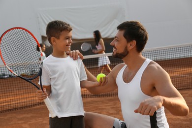 Father with his son on tennis court