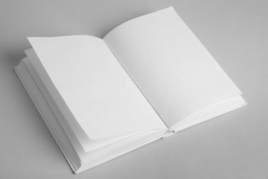 Open book with blank pages on grey background