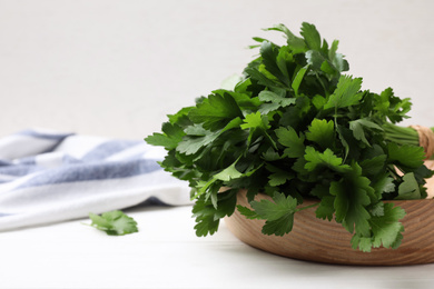 Bunch of fresh green parsley on white wooden table, closeup. Space for text