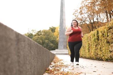 Beautiful overweight woman running in park. Fitness lifestyle