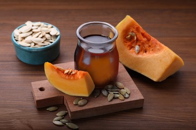 Fresh pumpkin seed oil in glass jar on wooden table