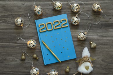 Planner and Christmas decor on wooden background, flat lay. 2022 New Year aims