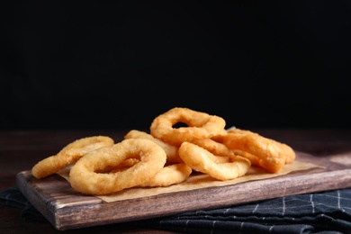 Fried onion rings served on wooden table
