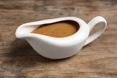 Delicious turkey gravy in sauce boat on wooden table