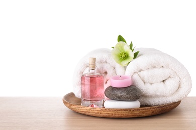 Tray with spa supplies on wooden table against white background
