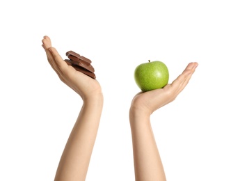 Photo of Concept of choice. Woman holding apple and chocolate on white background, closeup