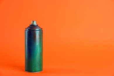 Used can of spray paint on orange background. Space for text