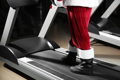 Authentic Santa Claus training on treadmill in modern gym, closeup