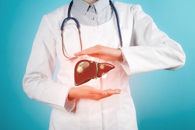 Image of Doctor with stethoscope and illustration of unhealthy liver on light blue background. Viral hepatitis