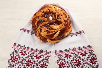 Rushnyk with korovai on white table, top view. Ukrainian bread and salt welcoming tradition