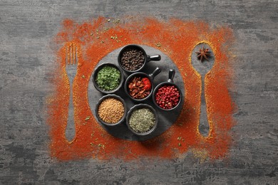 Photo of Different spices, silhouettes of cutlery and plate on grey table, flat lay