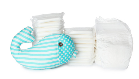 Photo of Disposable diapers and toy on white background
